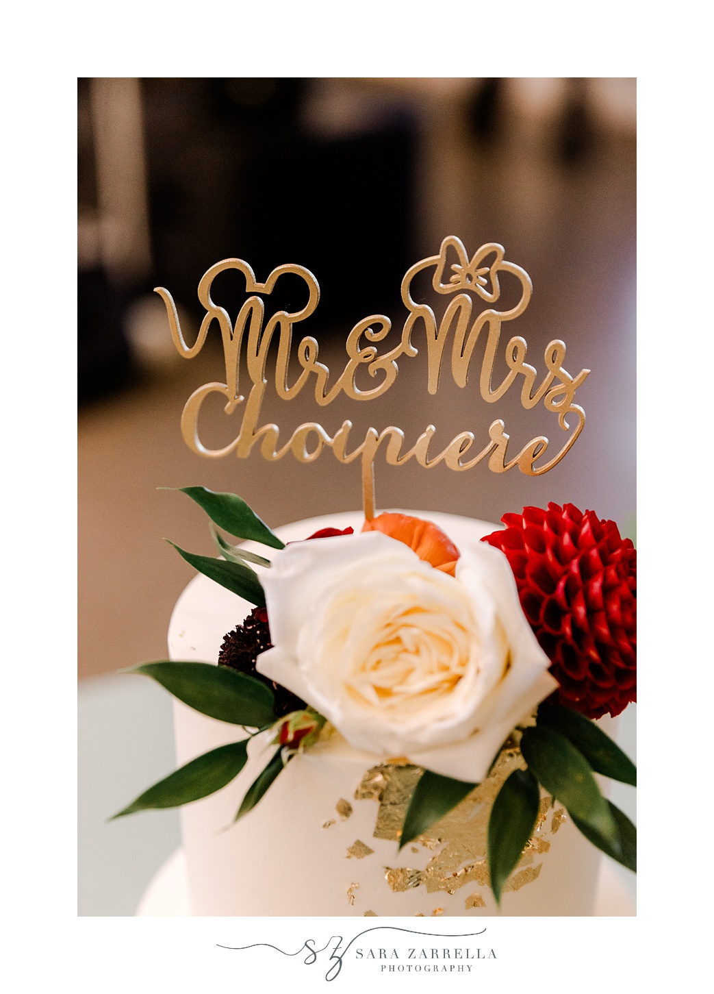 red and white flowers with gold Disney inspired cake topper