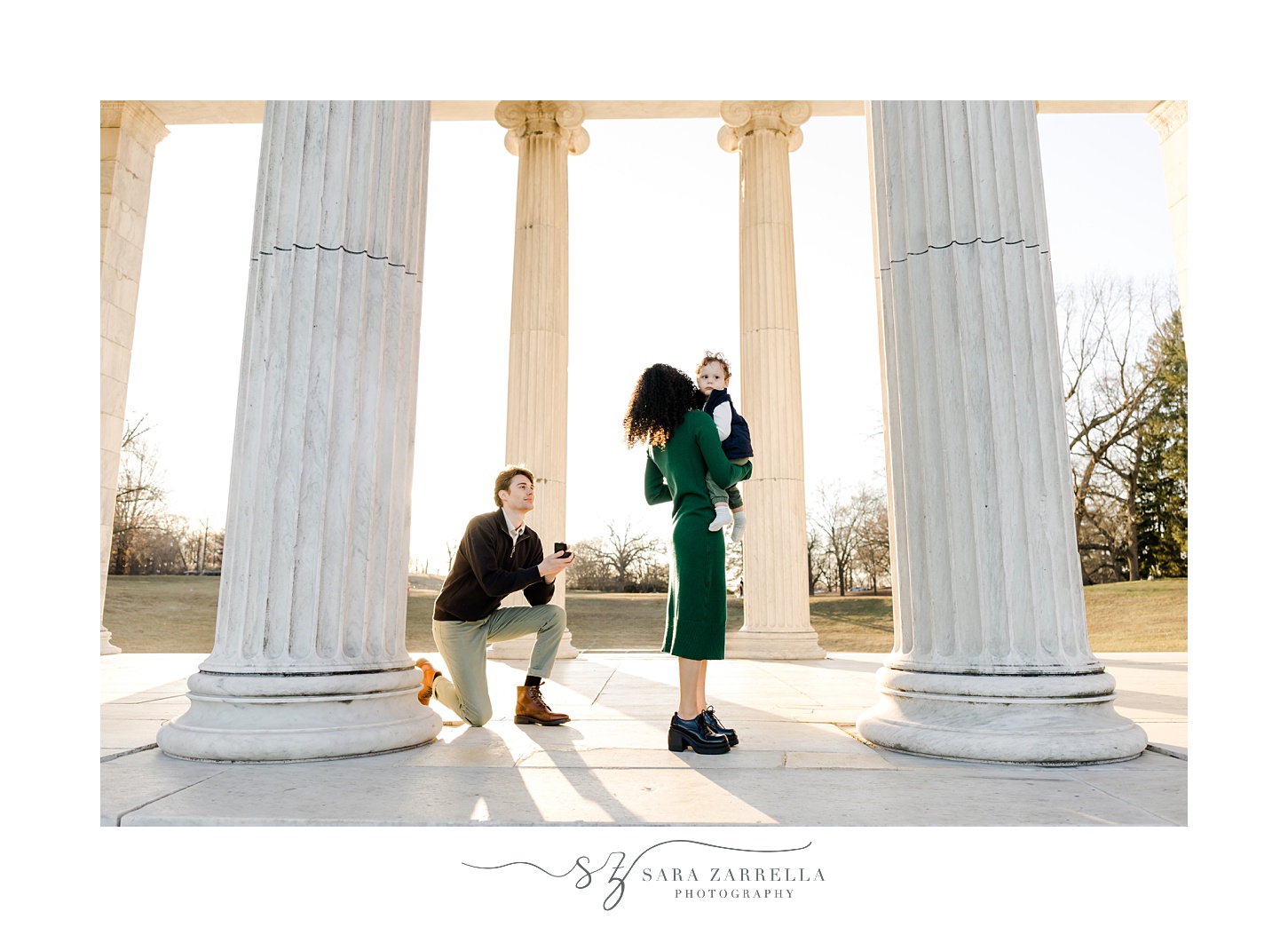 woman turns to see man kneeling during proposal at Roger Williams Park