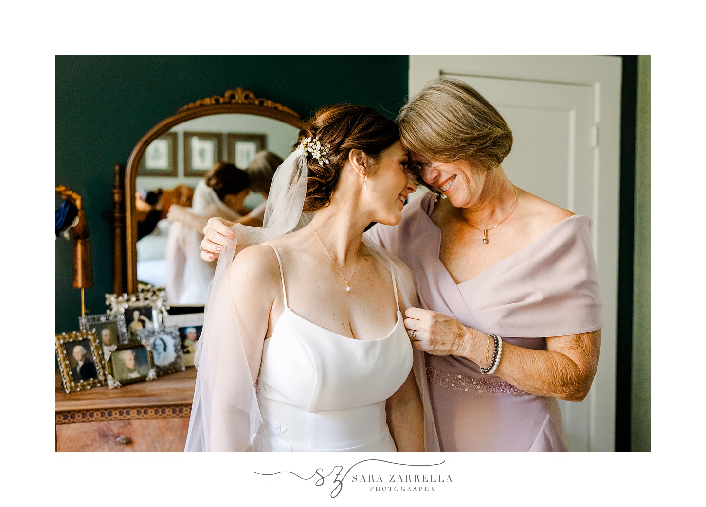 mom and bride lean heads together during prep for fall wedding day in North Kingstown RI