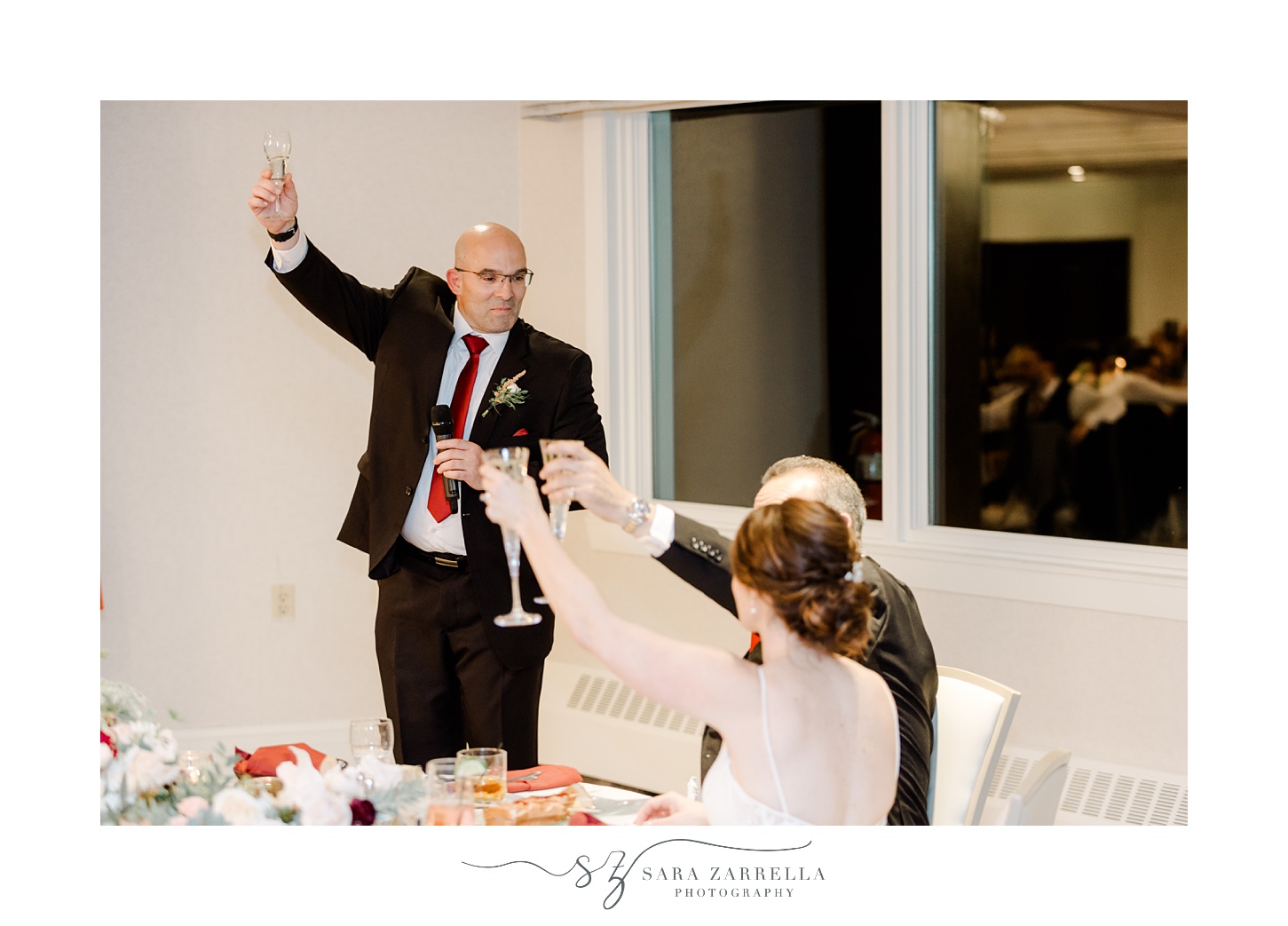 man raises glass during toasts during fall wedding reception in North Kingstown RI
