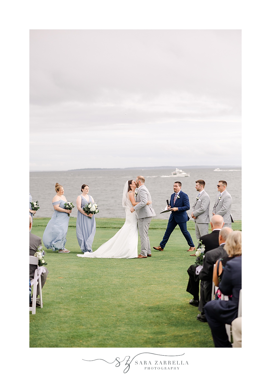 newlyweds kiss during waterfront wedding ceremony at Warwick Country Club