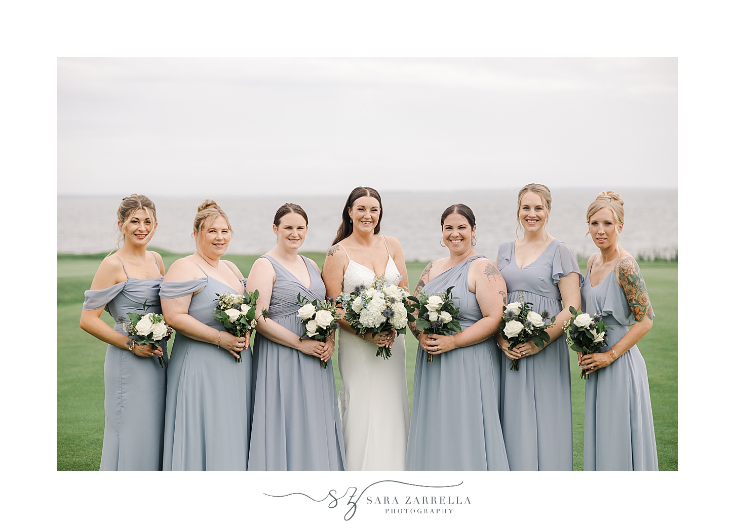 bride poses with bridesmaids in light blue gowns for coastal wedding at Warwick Country Club