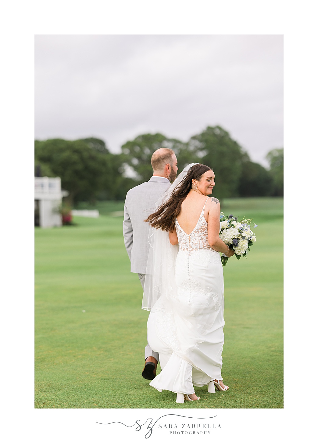 groom leads bride across lawn at Warwick Country Club